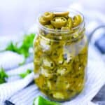 Square photo of pickled jalapeños in a mason jar.