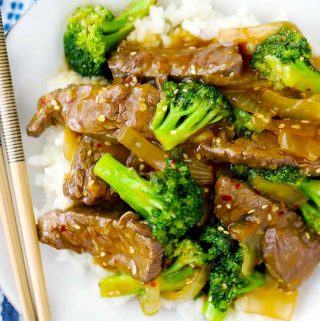 Beef and broccoli on a plate with chopsticks