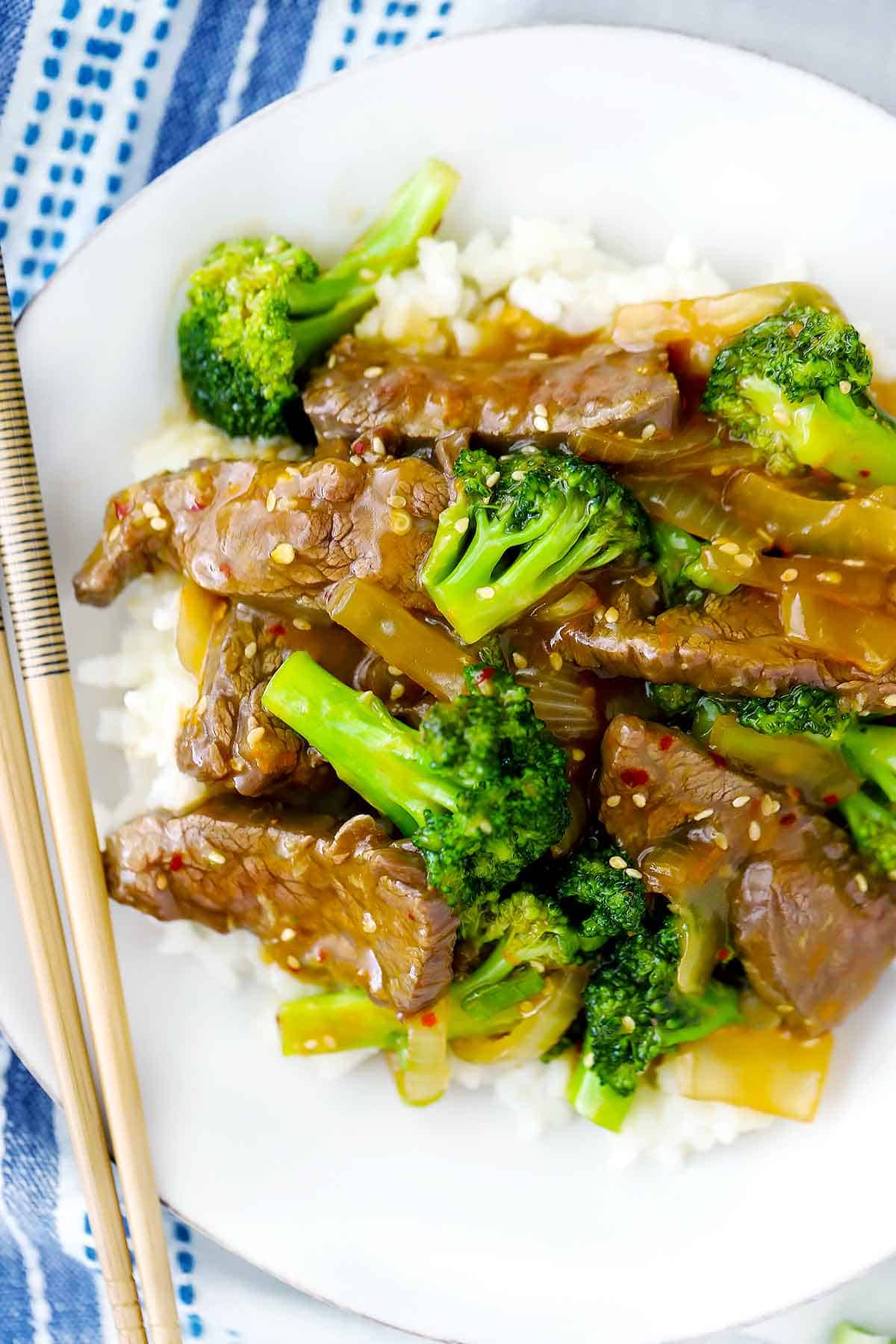 Beef and broccoli on a plate with chopsticks