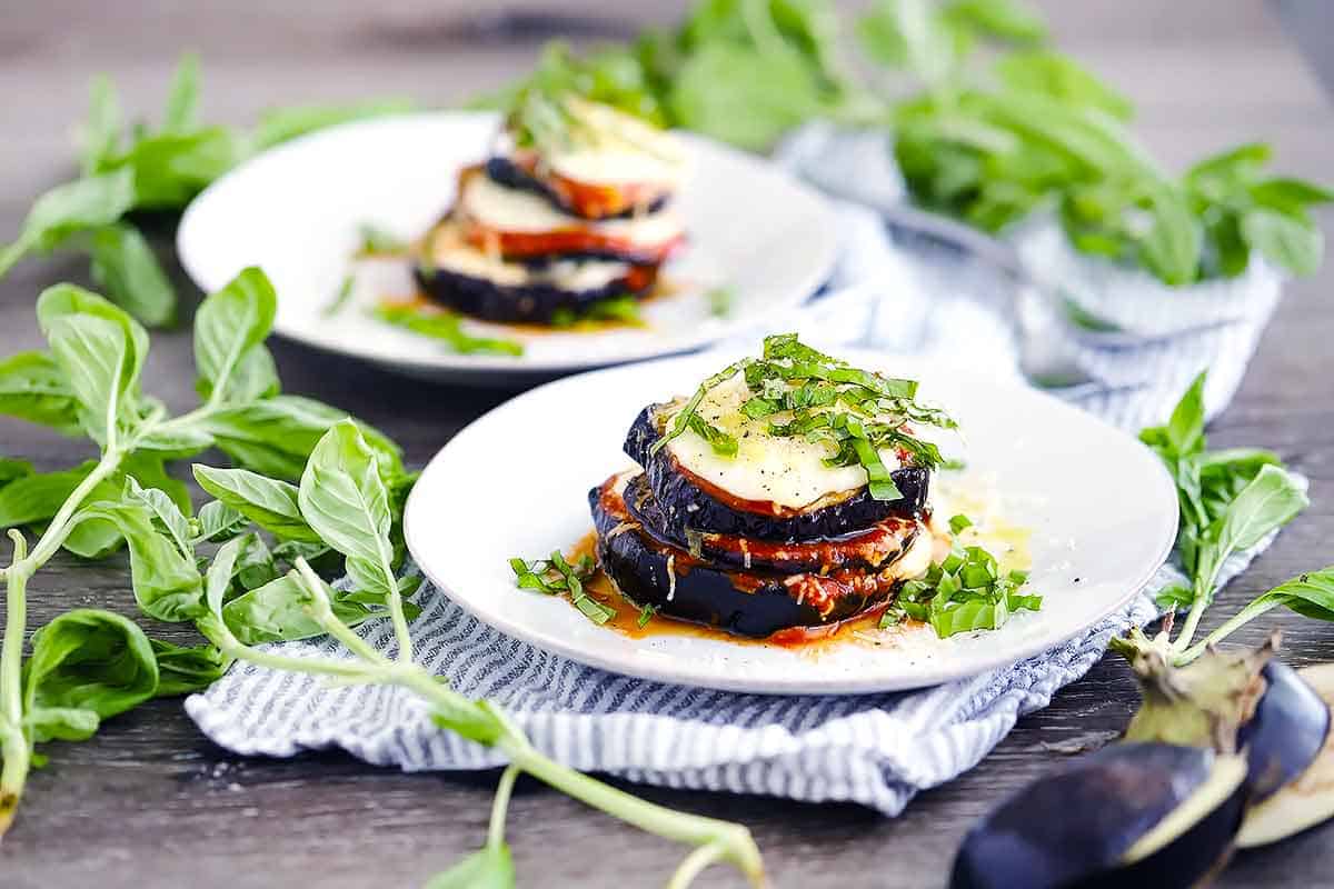 Two plates with eggplant parmesan stacks