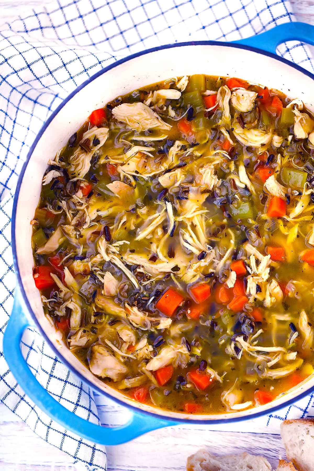 An overhead photo of chicken wild rice soup in a blue Dutch oven.