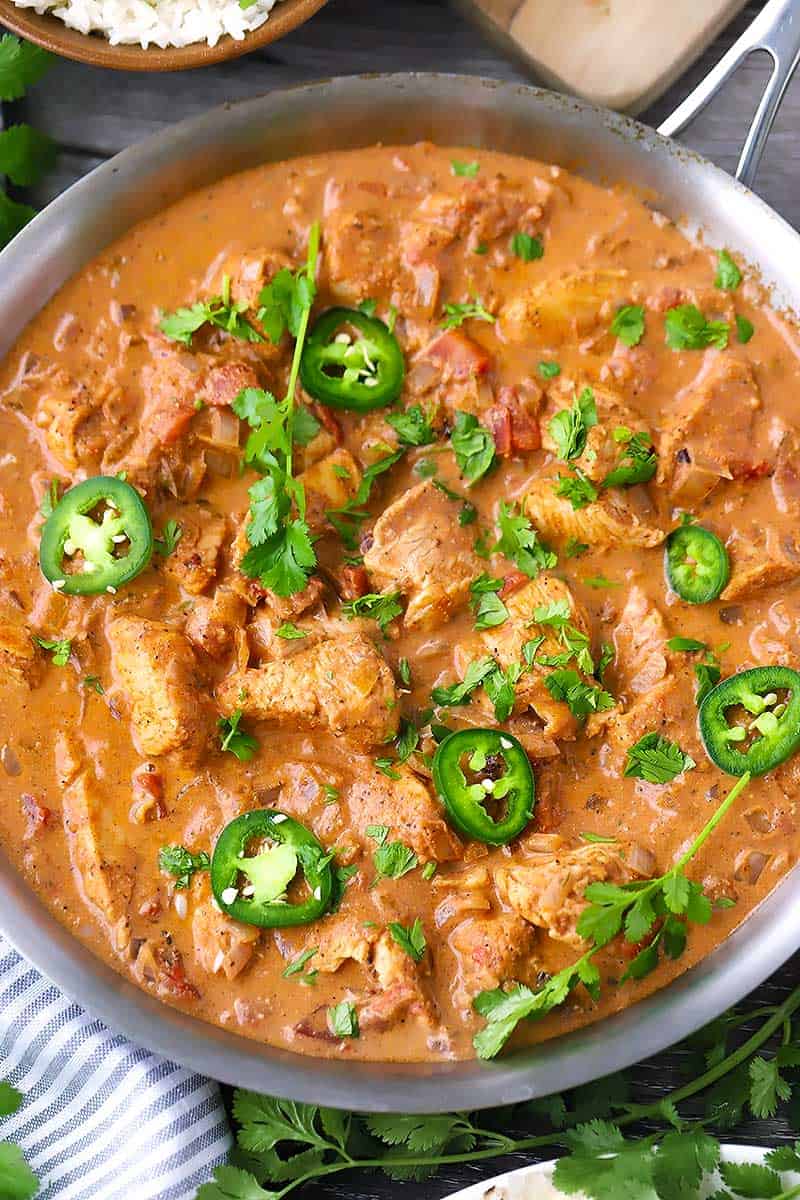 Close up photo of chicken tikka masala with jalapeños and cilantro on top.
