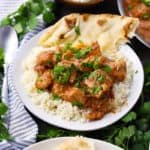 Square photo of chicken tikka masala with rice and naan.