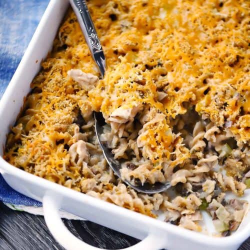 A casserole dish of tuna noodle casserole with a spoon scooping it out.