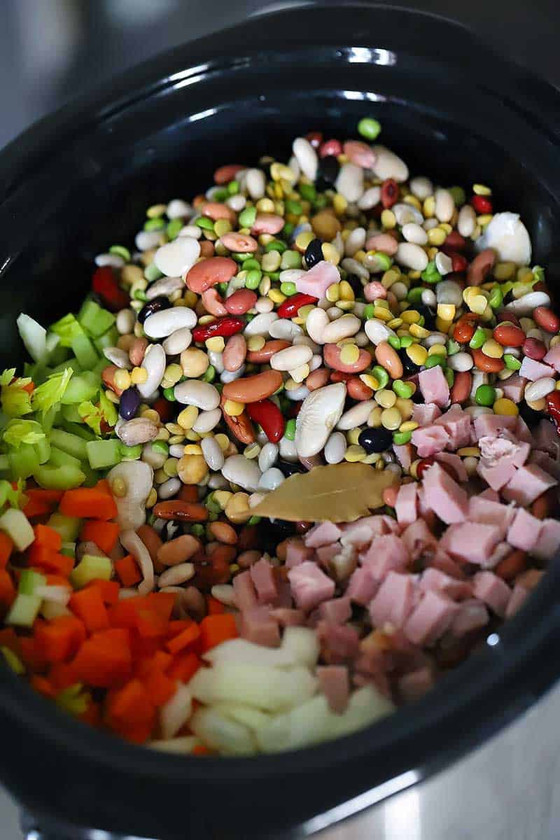 A crockpot with the ingredients for 15 bean soup before cooking.