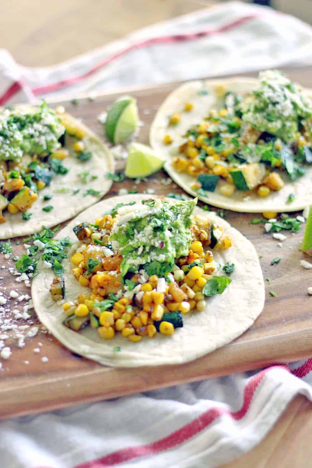 These zucchini and corn tacos with fresh guacamole are simple and healthy, have a bit of a kick, and take only ten minutes to make!