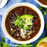 An overhead vertical image of a bowl of black bean soup.
