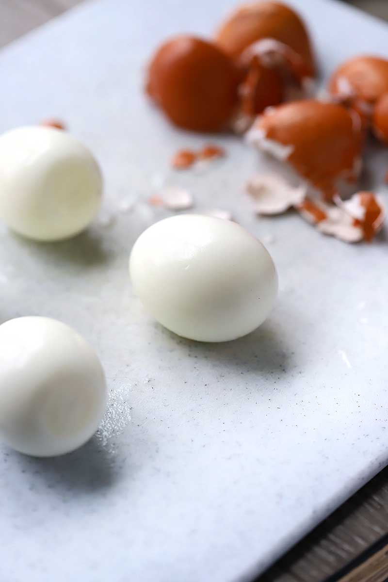 Peeled Hard boiled eggs with eggshells in background