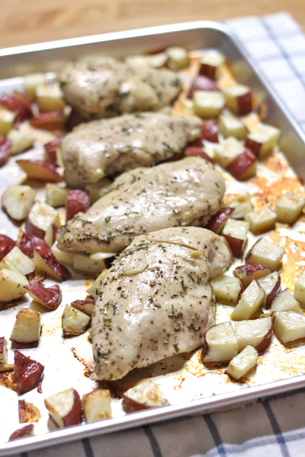 This healthy Whole30 and Paleo friendly rosemary and garlic roast chicken and potatoes dinner is SO easy, SO tasty, and uses only FOUR ingredients!