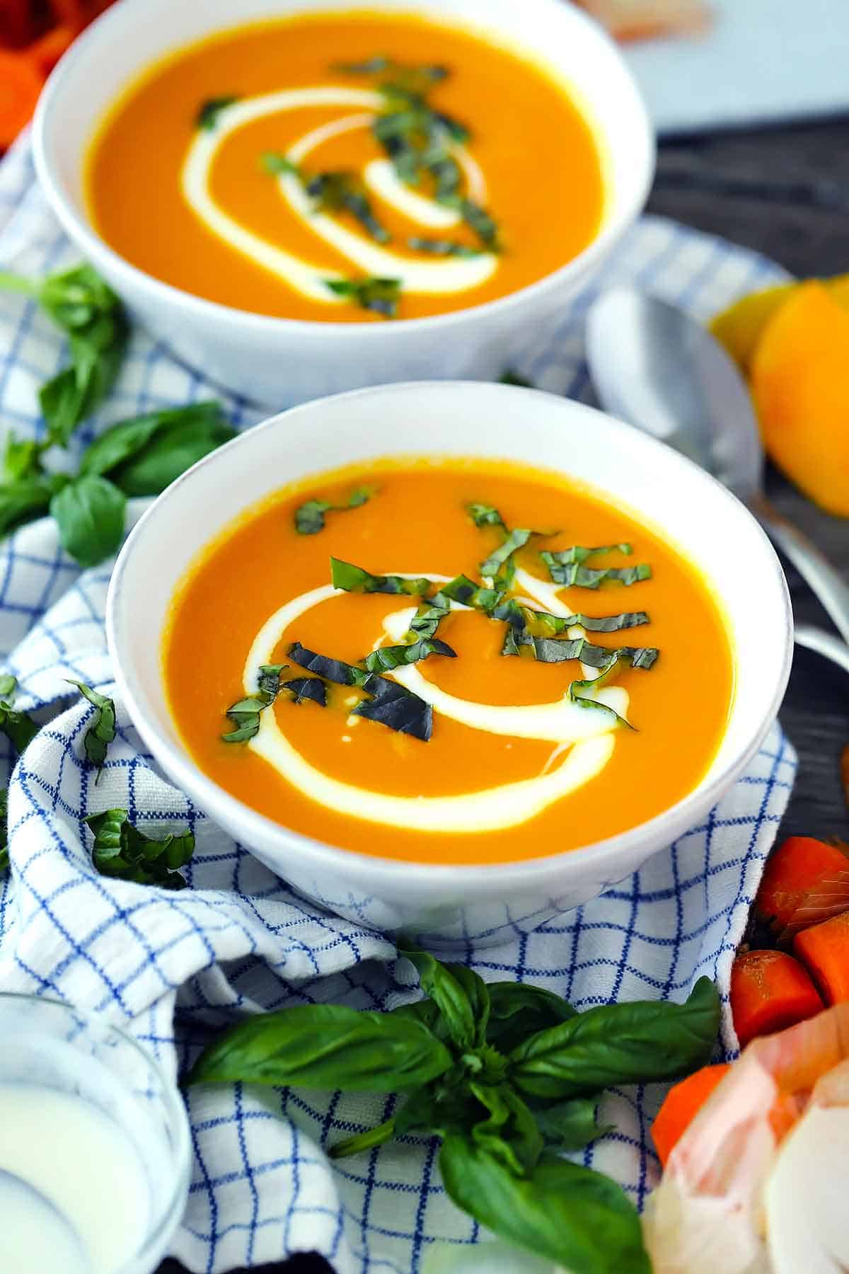 A white bowl filled with carrot soup.