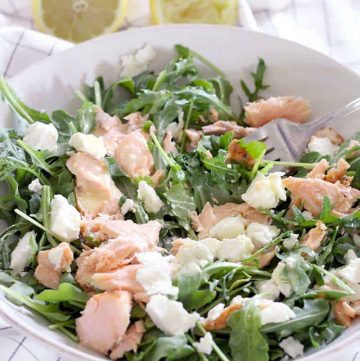 Salmon, Goat Cheese, and Arugula Salad with Creamy Lemon Garlic Dressing! Use up cold leftover salmon in this simple, easy salad. The dressing is AMAZING, and has a secret ingredient that helps emulsify it and add a creamy texture with no dairy!