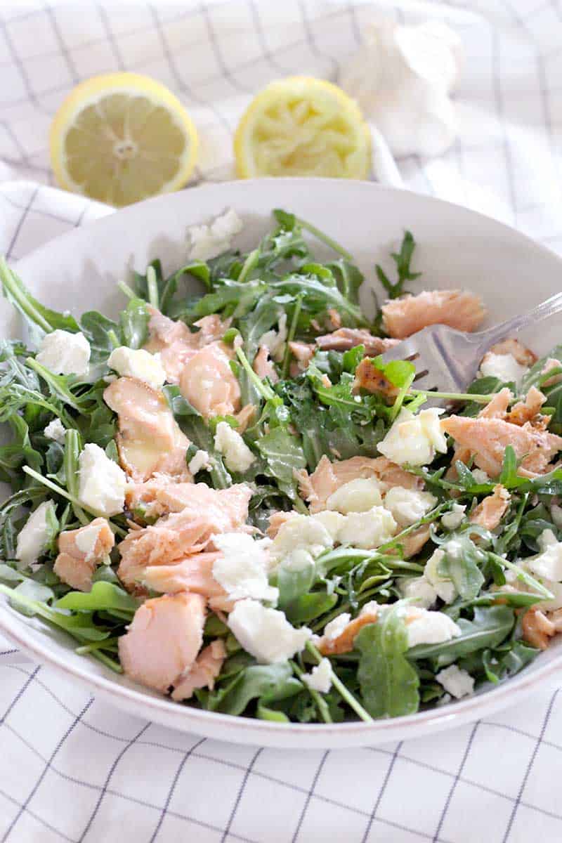 Salmon, Goat Cheese, and Arugula Salad with Creamy Lemon Garlic Dressing! Use up cold leftover salmon in this simple, easy salad. The dressing is AMAZING, and has a secret ingredient that helps emulsify it and add a creamy texture with no dairy!