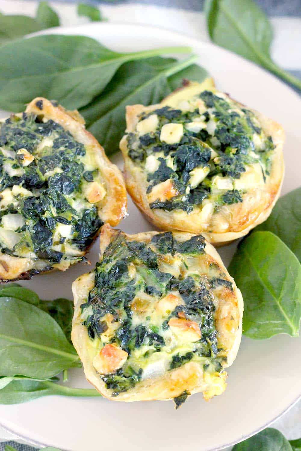 These Mini Spinach Feta pies are an easy alternative to traditional Greek Spanakopita, with only 5 ingredients and 10 minutes of hands on time! These are packed FULL of healthy spinach, and a perfect vegetarian entree or appetizer.