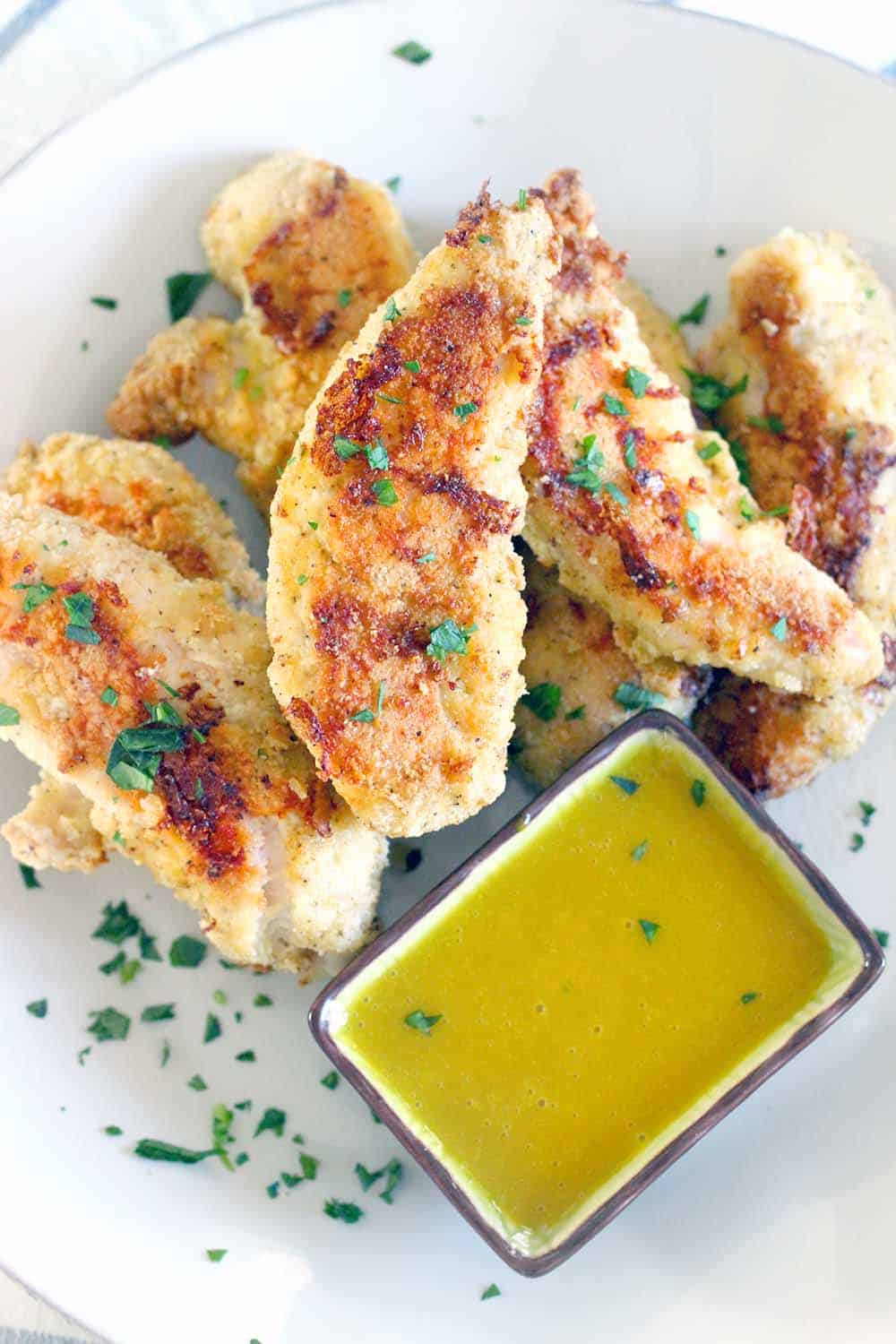 These Paleo Oven-Fried Chicken Tenders are grain-free and gluten-free, easy to make, and kid-friendly with a simple honey mustard dipping sauce. Perfect for game day or a casual weeknight dinner!
