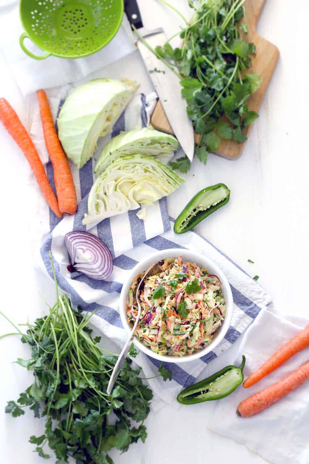 This easy, delicious recipe for Spicy Jalapeno Cilantro Slaw is great as a side, or on top of your favorite pulled pork sandwiches or fish tacos! Vegetarian, vegan optional, low carb, and paleo compliant.