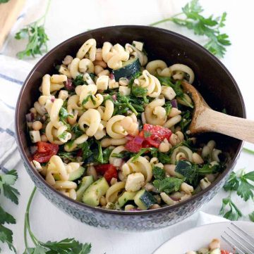 This refreshing Greek Pasta Salad with Herb Vinaigrette recipe is packed with healthy ingredients like white beans, arugula, and fresh veggies. The perfect Mediterranean vegetarian meal or side!
