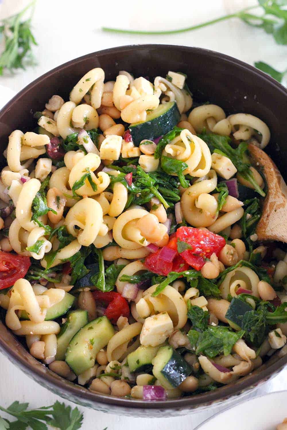 This refreshing Greek Pasta Salad with Herb Vinaigrette recipe is packed with healthy ingredients like white beans, arugula, and fresh veggies. The perfect Mediterranean vegetarian meal or side!