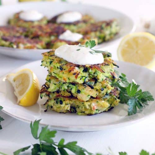 This healthy Shrimp and Zucchini Fritters with Yogurt Sauce recipe is a delicious way to eat your veggies! The yogurt sauce is garlicky with lemon, and the zucchini and shrimp stand out in the simple fritters and are a match made in heaven.