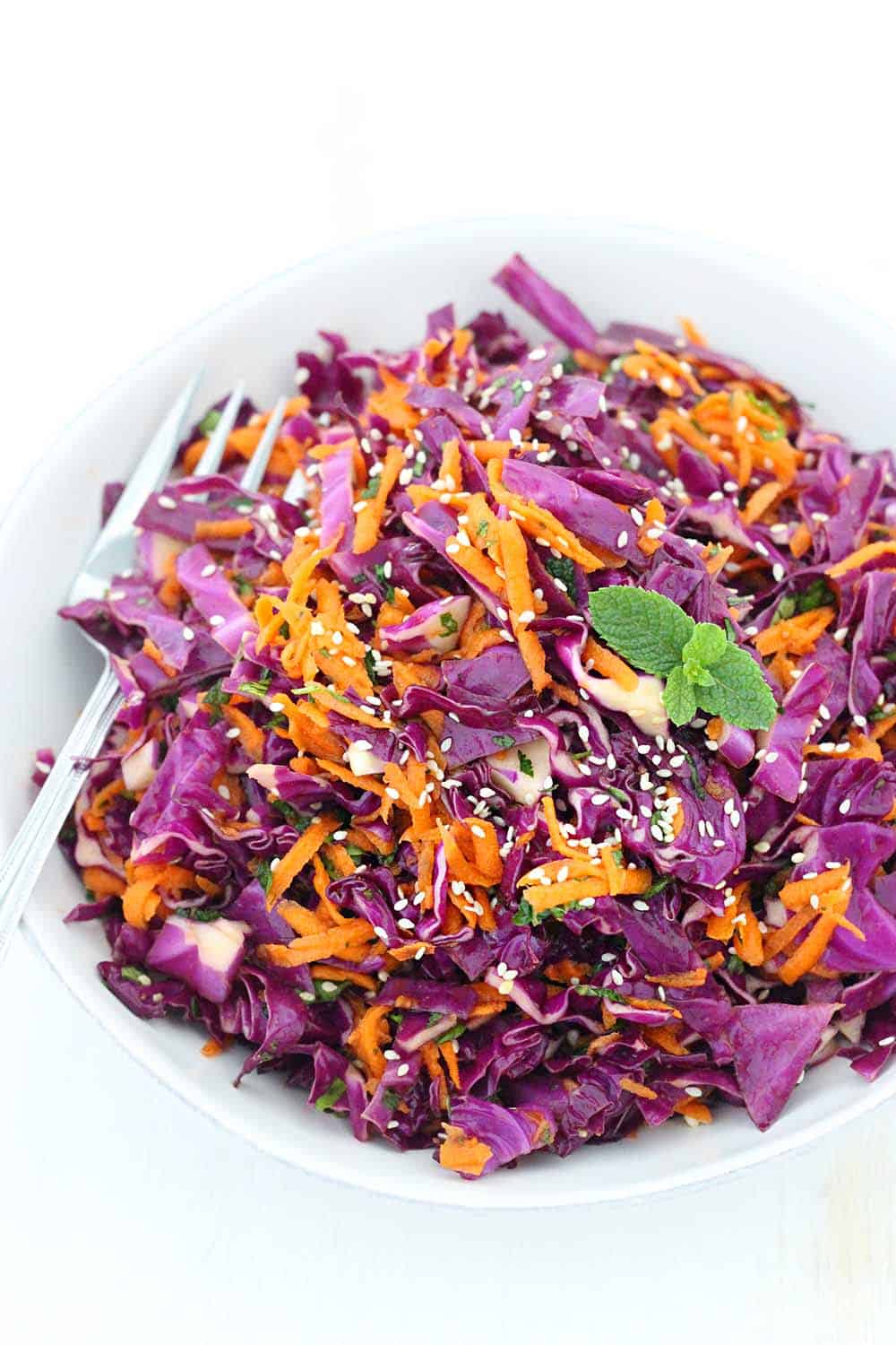 This Thai Sesame Red Cabbage and Carrot Salad recipe is cool, crunchy, healthy, and refreshing. Packed with flavor from fresh mint, basil, and cilantro and a toasted sesame dressing!