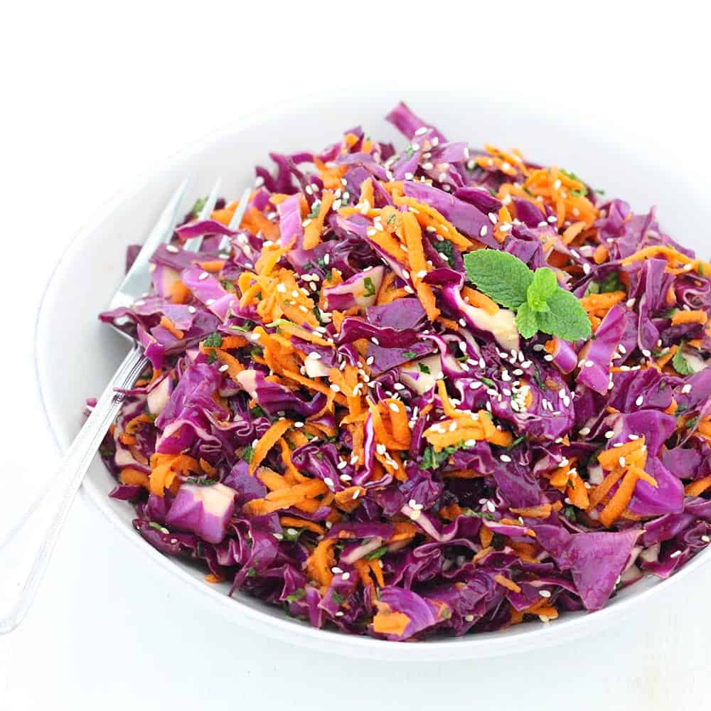 This Thai Sesame Red Cabbage and Carrot Salad recipe is cool, crunchy, healthy, and refreshing. Packed with flavor from fresh mint, basil, and cilantro and a toasted sesame dressing!