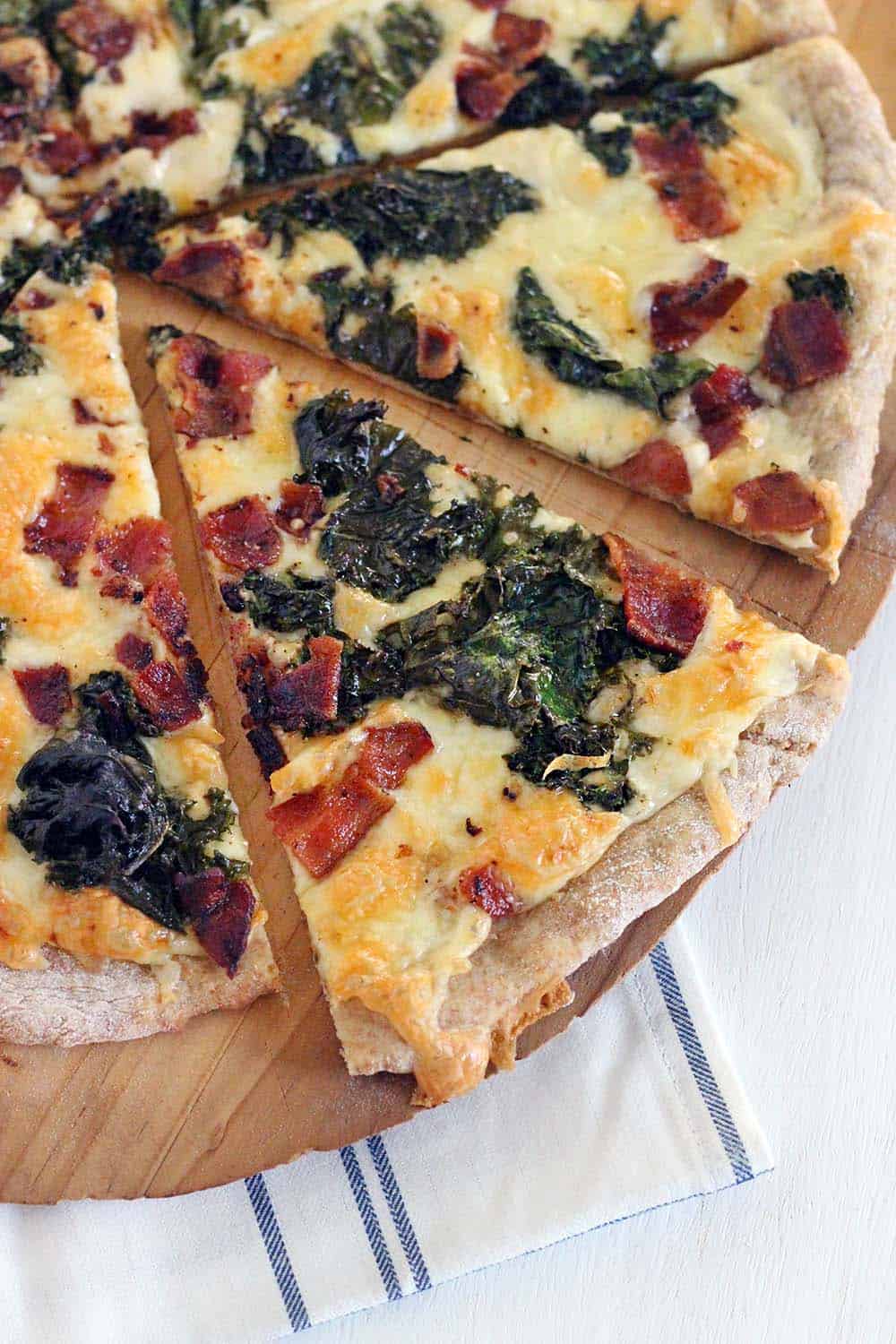 This Bacon and Kale Pizza is topped with super crispy kale and bacon pieces. This recipe comes together with only 5 ingredients in under 30 minutes!