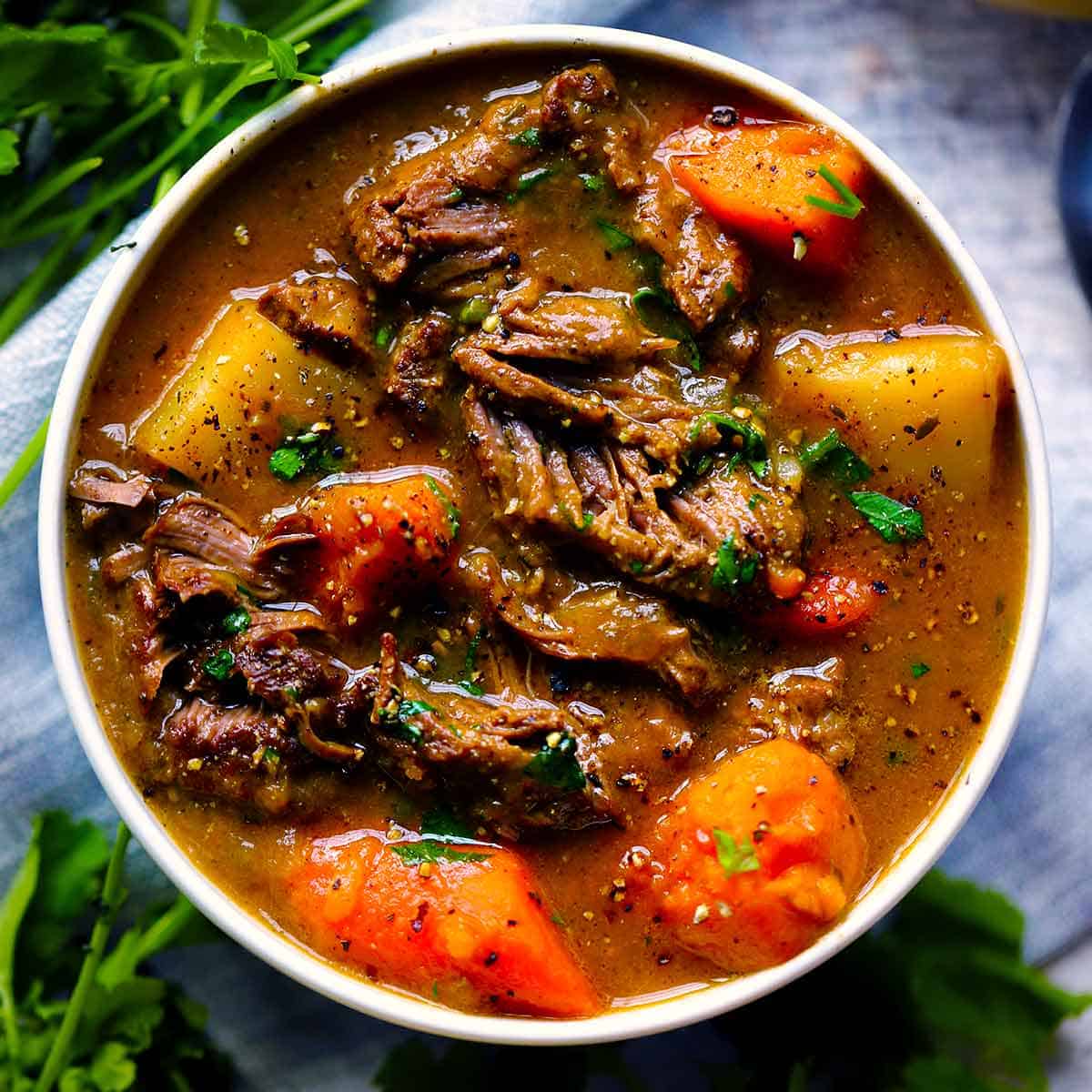 This simple Irish Lamb and Potato Stew is cooked in a dutch oven and is warm and comforting during cold weather. Sweet potatoes and dark beer are added for amazing depth of flavor, with no flour needed as a thickener. Easily adaptable to be paleo/whole30 compliant! #IrishFood #Paleo #LambStew