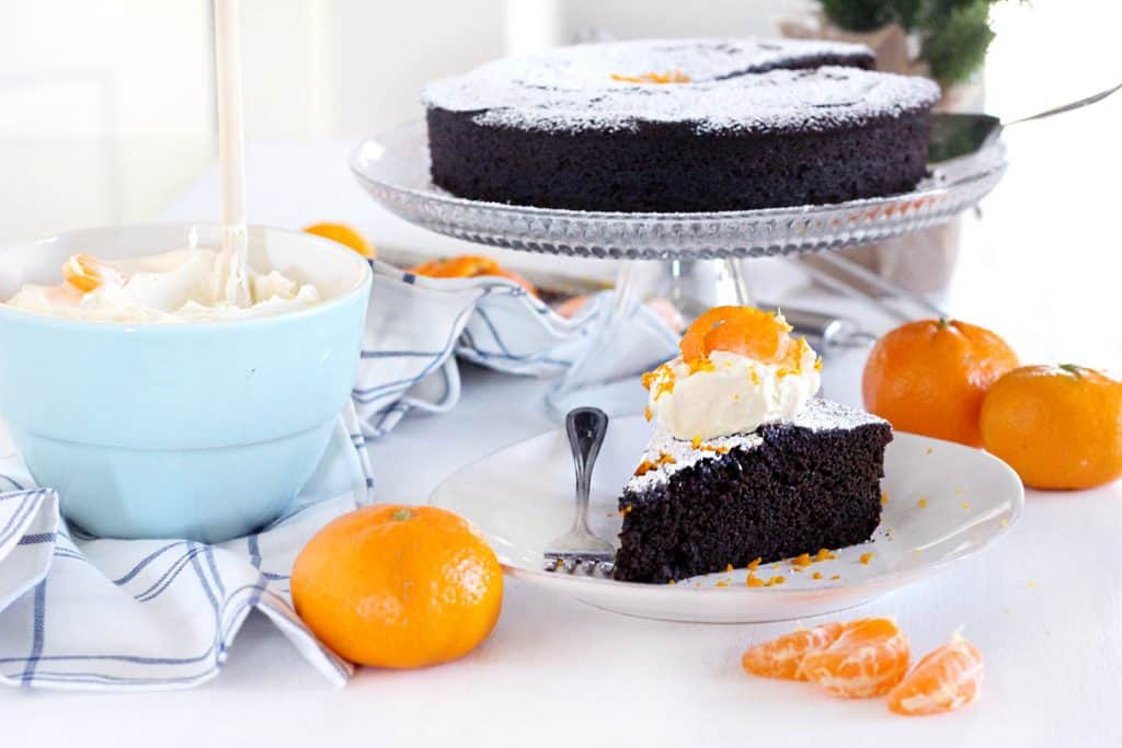This spicy gingerbread cake with orange mascarpone cream is packed with fresh ginger flavor and all the holiday spices you love! It's not too sweet and has very little refined sugar, and pairs perfectly with the light, fluffy whipped cream made with mascarpone cheese and fresh orange zest and juice. It's the perfect holiday dessert! #Gingerbread #Oranges #WhippedCream #HolidayBaking #GingerbreadCake #LowSugar 