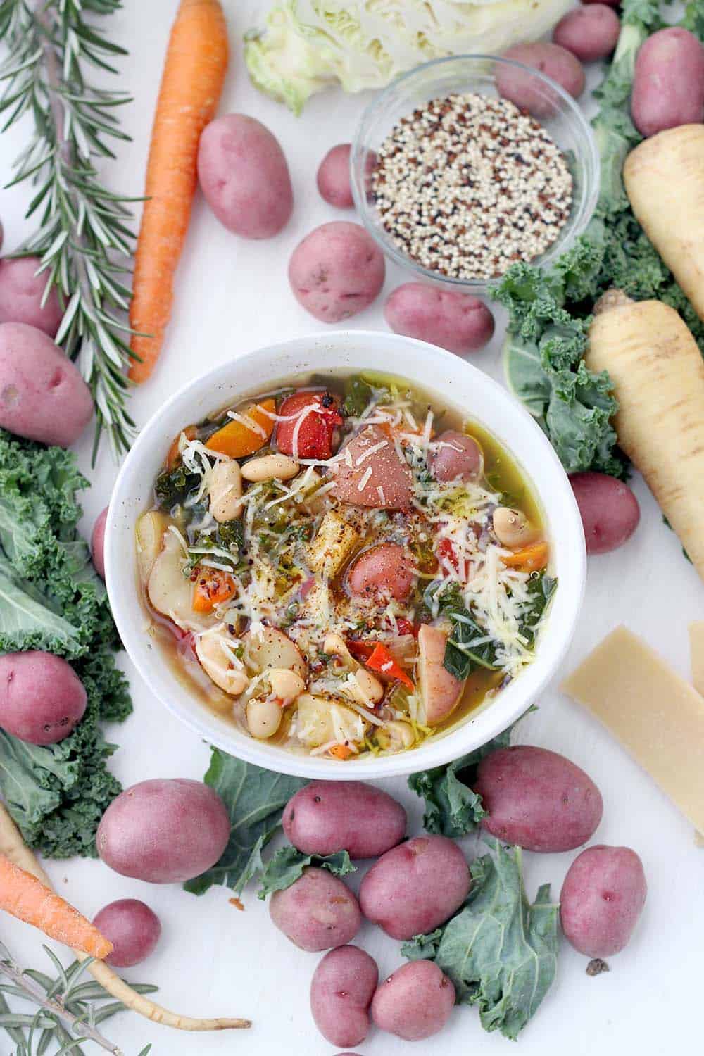 This Winter Minestrone Soup is packed with seasonal root vegetables like potatoes, parsnips, cabbage, and kale, as well as healthy quinoa and beans. Topped with plenty of extra-virgin olive oil and parmesan cheese, it's a delicious, hearty recipe to keep you warm this winter! Stovetop, Slow Cooker, and Instant Pot friendly.