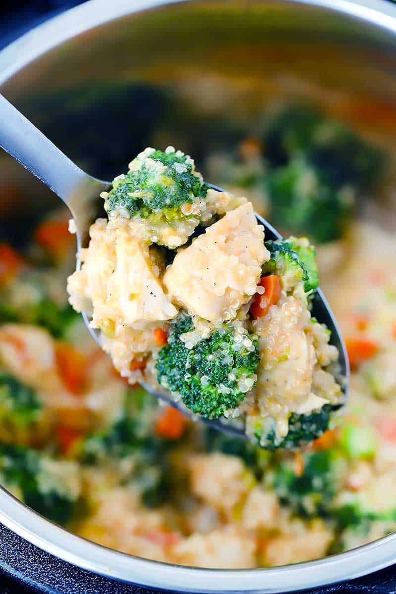 A spoonful of chicken, broccoli, quinoa, and carrots.