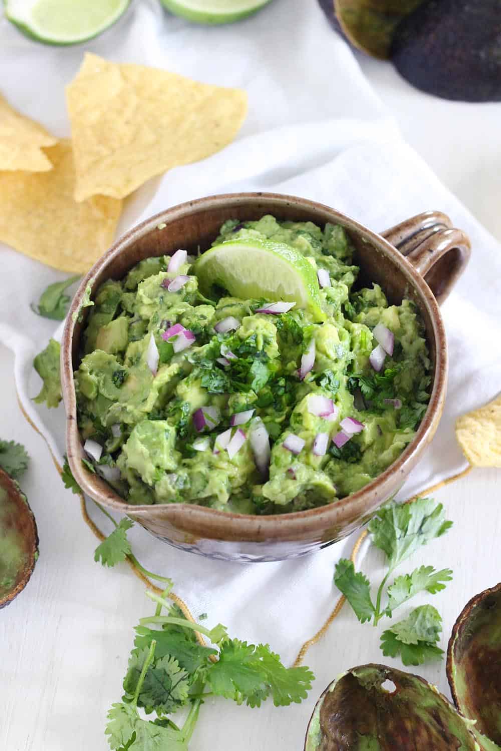This simple guacamole recipe is truly the best- nothing but avocado, cilantro, lime juice, salt, and a little bit of red onion. The avocado is diced rather than mashed for the ideal chunky texture. Eat it with tortilla chips, on toast, on tacos or burritos, top eggs or fish or chicken with it, or eat with a spoon directly from the bowl!