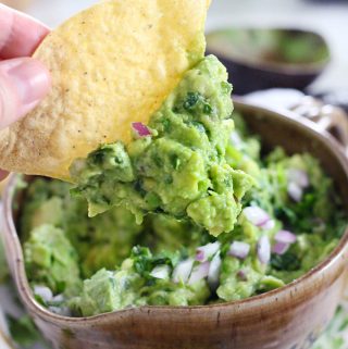 This simple guacamole recipe is truly the best- nothing but avocado, cilantro, lime juice, salt, and a little bit of red onion. The avocado is diced rather than mashed for the ideal chunky texture. Eat it with tortilla chips, on toast, on tacos or burritos, top eggs or fish or chicken with it, or eat with a spoon directly from the bowl!