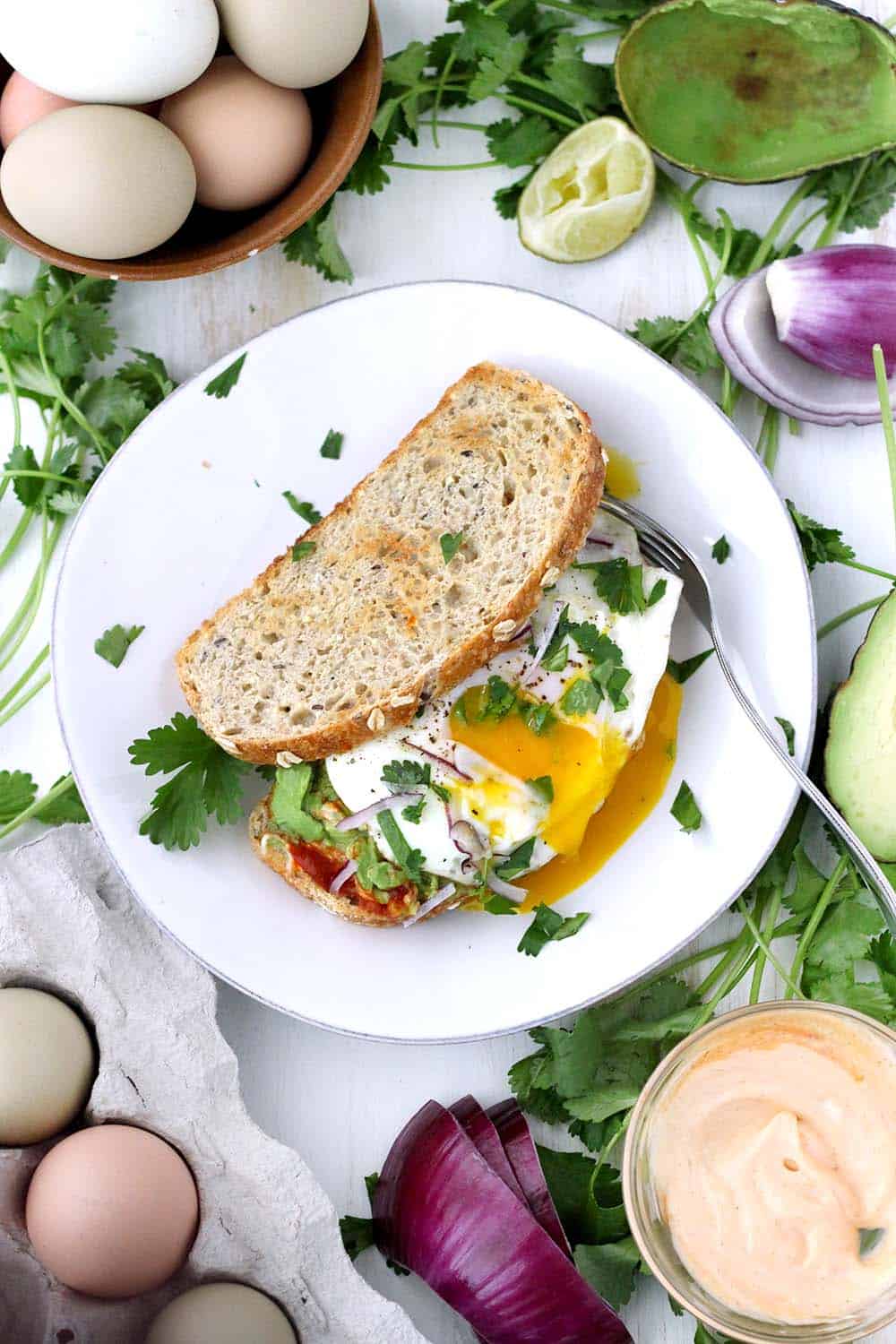 This Vegetarian Breakfast Sandwich Recipe is my absolute favorite. Features smashed avocado, Sriracha mayo, and a perfect sunny-side-up egg, with a little lime juice, cilantro, and red onion for extra flavor. It's easy to make for a hearty weekend breakfast or brunch!