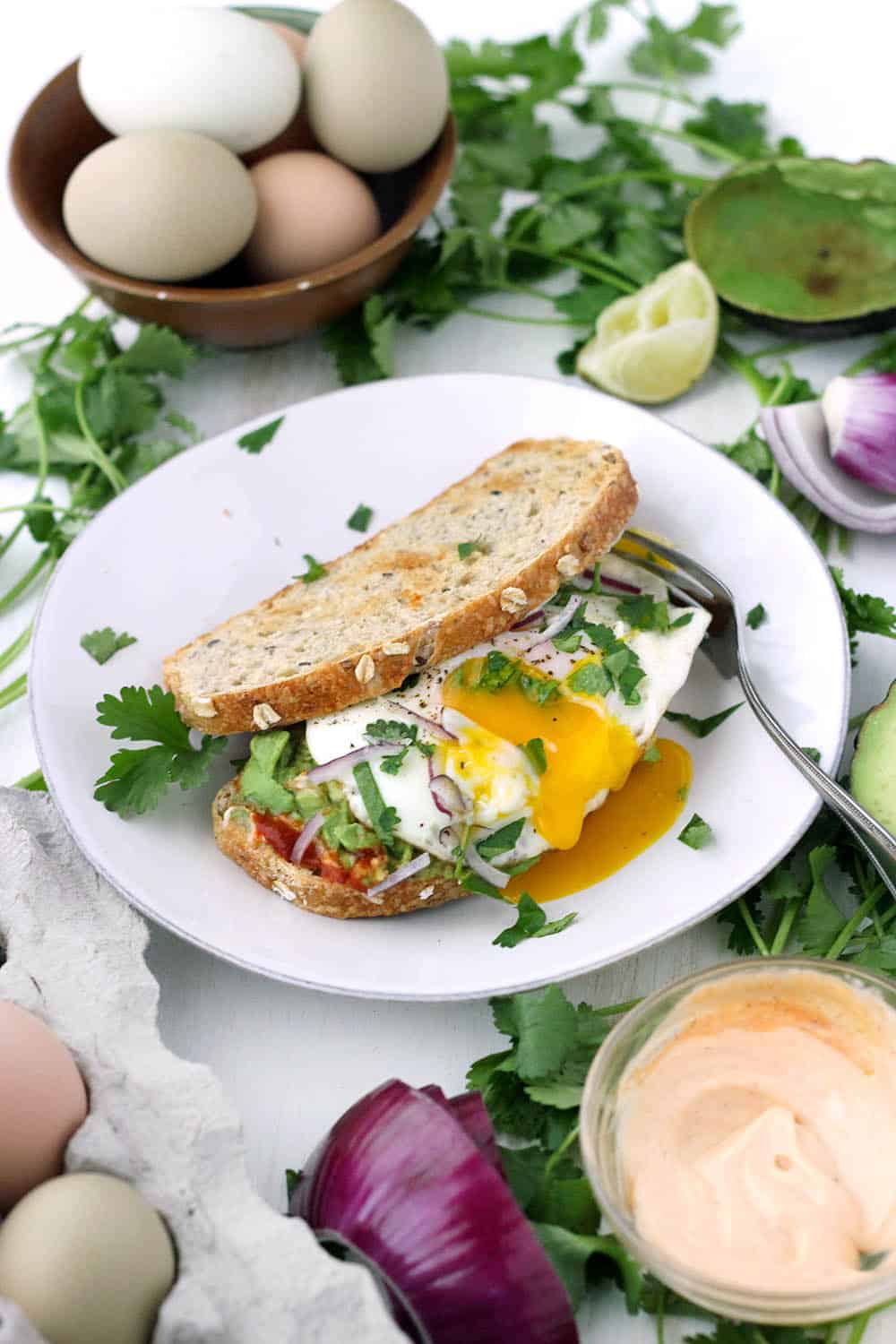 This Vegetarian Breakfast Sandwich Recipe is my absolute favorite. Features smashed avocado, Sriracha mayo, and a perfect sunny-side-up egg, with a little lime juice, cilantro, and red onion for extra flavor. It's easy to make for a hearty weekend breakfast or brunch!