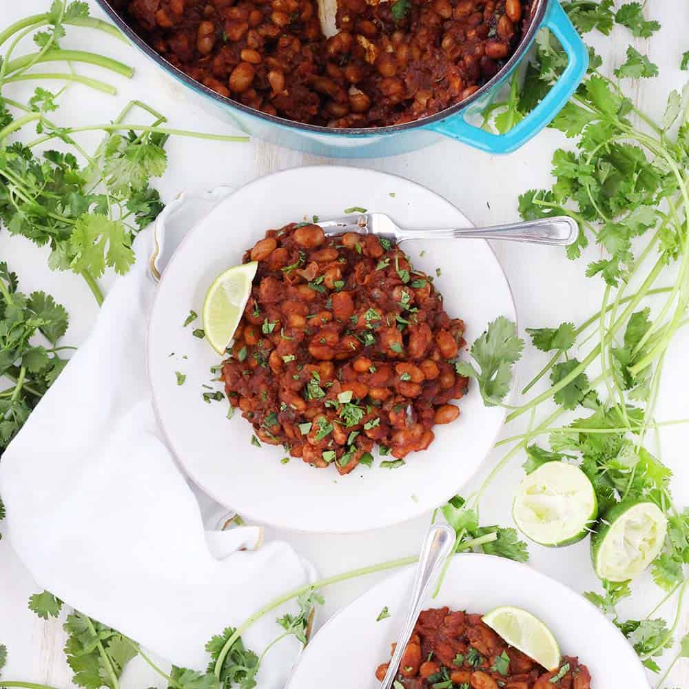 These Mexican Baked Beans with Chorizo are smoky, sweet, and spicy! This gluten free recipe makes a TON, and it's freezable. Serve as a side at your next BBQ, piled on toast, or with fried eggs for brunch.