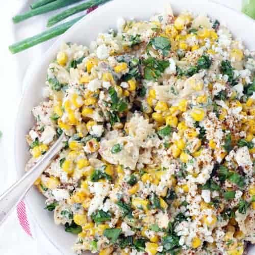 This Mexican Street Corn Pasta Salad is PACKED with sweet corn and tossed in a creamy chili lime dressing. With plenty of queso fresco, bacon, jalapeño, and green onions, this flavor-packed recipe is perfect for a potluck! Can be made with frozen, fresh, or canned corn. Plus, no grilling required! For extra smoky and charred flavor without grilling, the corn is sautéed in bacon fat.