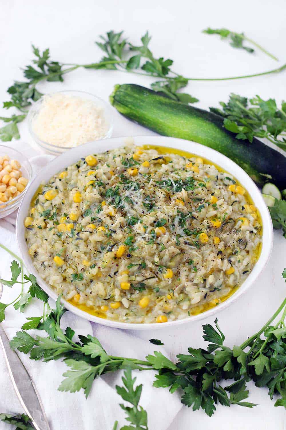This vegetarian sweet corn and zucchini risotto recipe is such a great way to enjoy summertime vegetables! The zucchini is grated, so it melts into every bite while still maintaining a great texture, and the corn cobs are used to add flavor and starch to the broth base. The leftovers are great for brunch served with a fried egg on top.