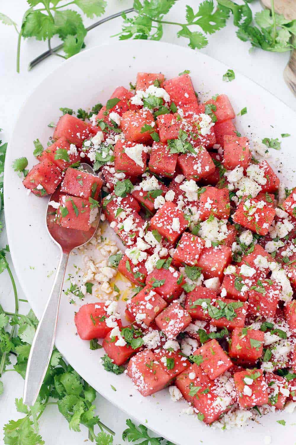 This refreshing watermelon salad with queso fresco, lime, and cilantro is the perfect balance of sweet and salty! It's easy to make this vegetarian side dish in advance and perfect for your summer festivities.