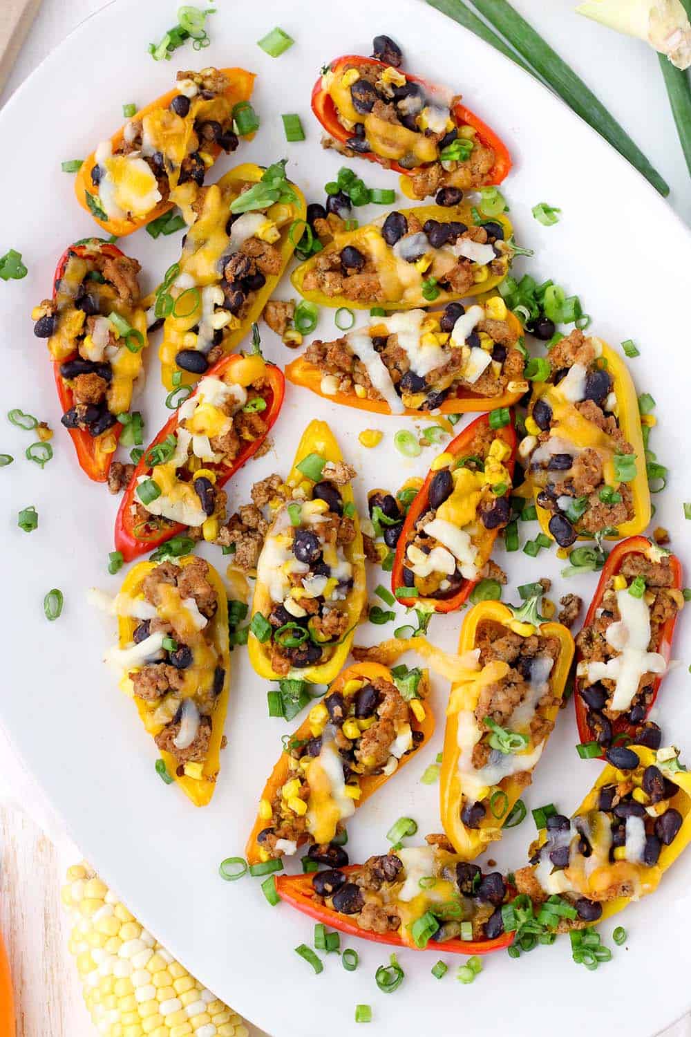 These Taco Stuffed Mini Peppers are the perfect appetizer or light meal! The sweet mini peppers are filled with slightly spicy, taco flavored ground turkey, black beans, and corn for a super fun, low-carb finger food.