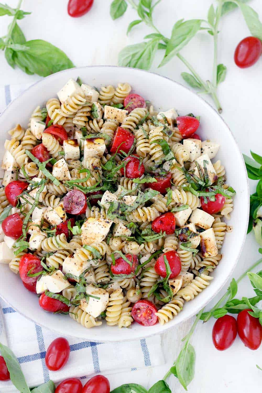 This fast and easy Caprese Pasta Salad recipe is coated in a light, creamy balsamic and olive oil dressing. A great vegetarian weeknight dinner, or add grilled chicken to make it more hearty.