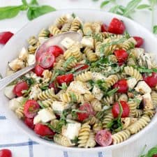 This fast and easy Caprese Pasta Salad recipe is coated in a light, creamy balsamic and olive oil dressing. A great vegetarian weeknight dinner, or add grilled chicken to make it more hearty.