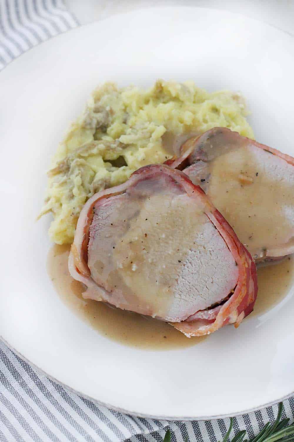 Roasted Bacon Wrapped Pork Loin served with Mashed Potatoes and Apple Cider Gravy