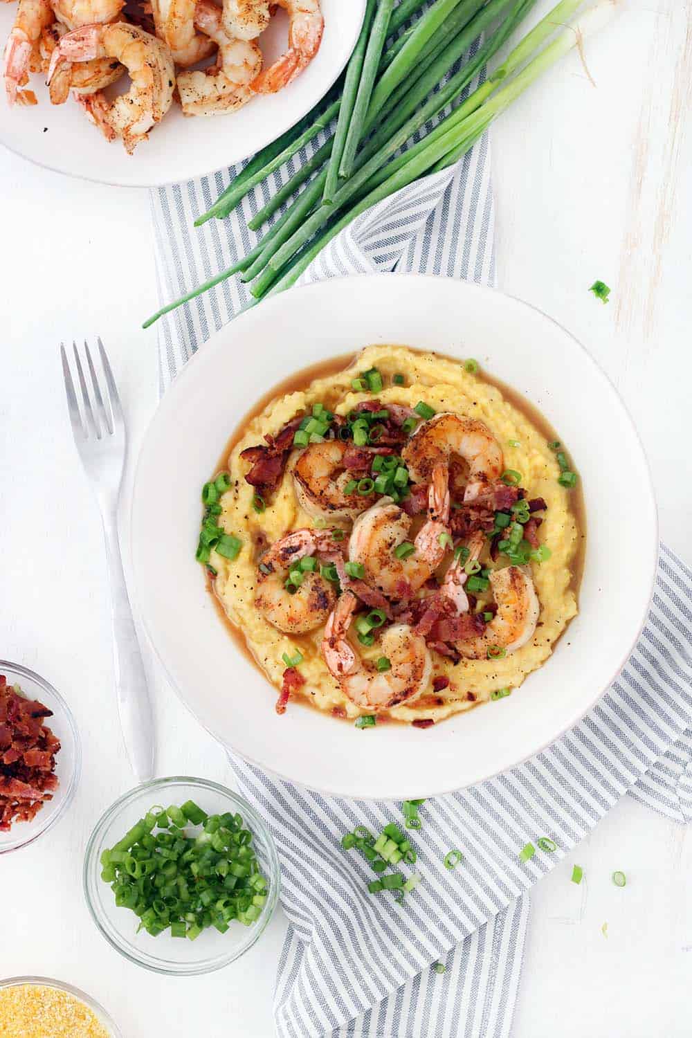 This classic Shrimp and Grits recipe is easy to make and is such delicious Southern comfort food! The cheesy grits are cheap and gluten free, and make an excellent base for the flavorful shrimp and crumbled bacon.