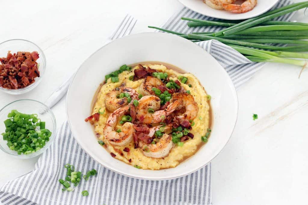 This classic Shrimp and Grits recipe is easy to make and is such delicious Southern comfort food! The cheesy grits are cheap and gluten free, and make an excellent base for the flavorful shrimp and crumbled bacon.