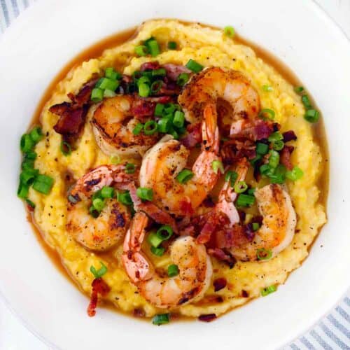 Square photo of a white bowl of shrimp and grits.