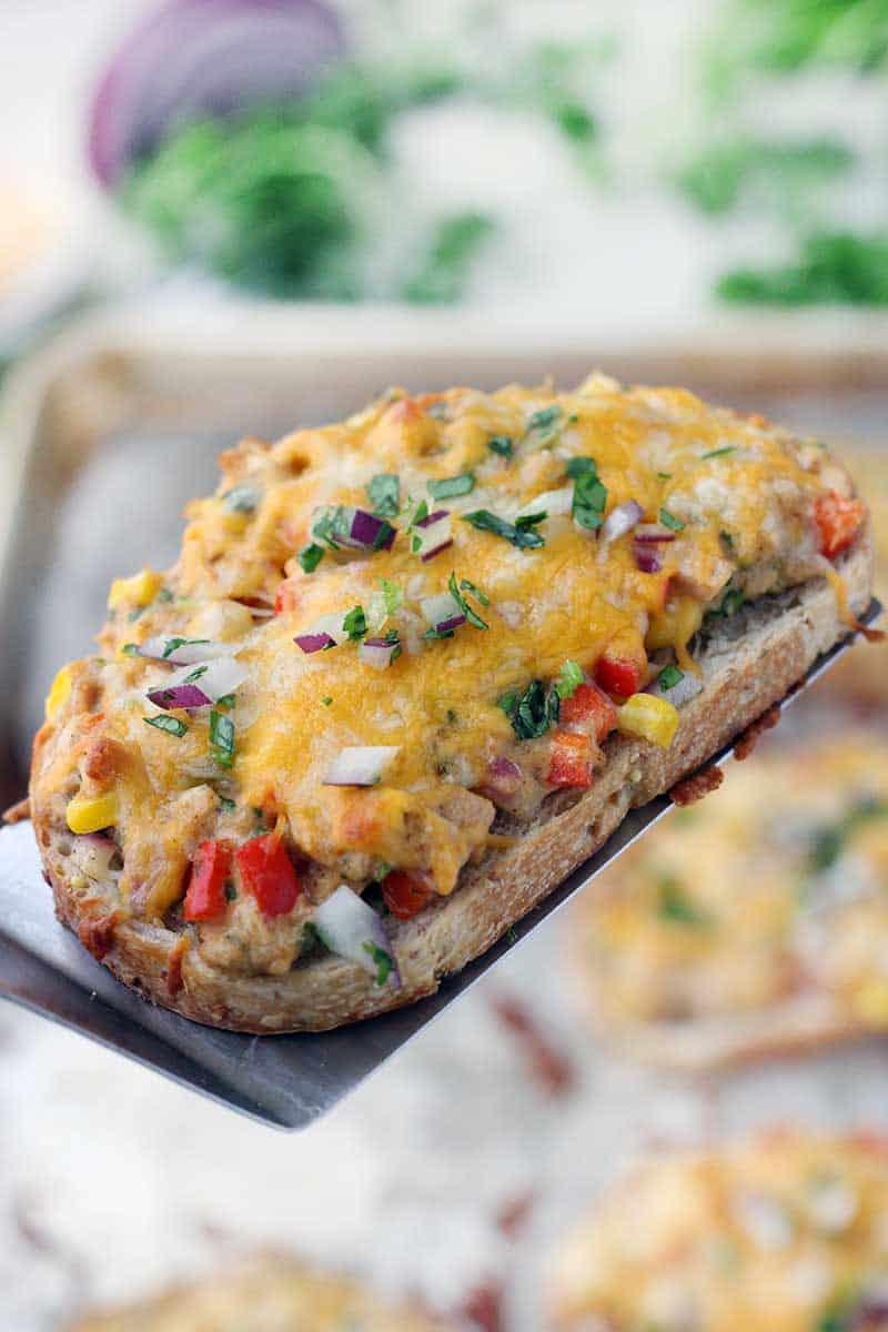 Tex Mex Tuna Melts are such a fun twist on a classic! Corn, bell peppers, jalapeño, cilantro, and onion are mixed in tuna, spread on bread, and topped with Mexican cheese, then baked until melty. Such an easy weeknight dinner recipe!