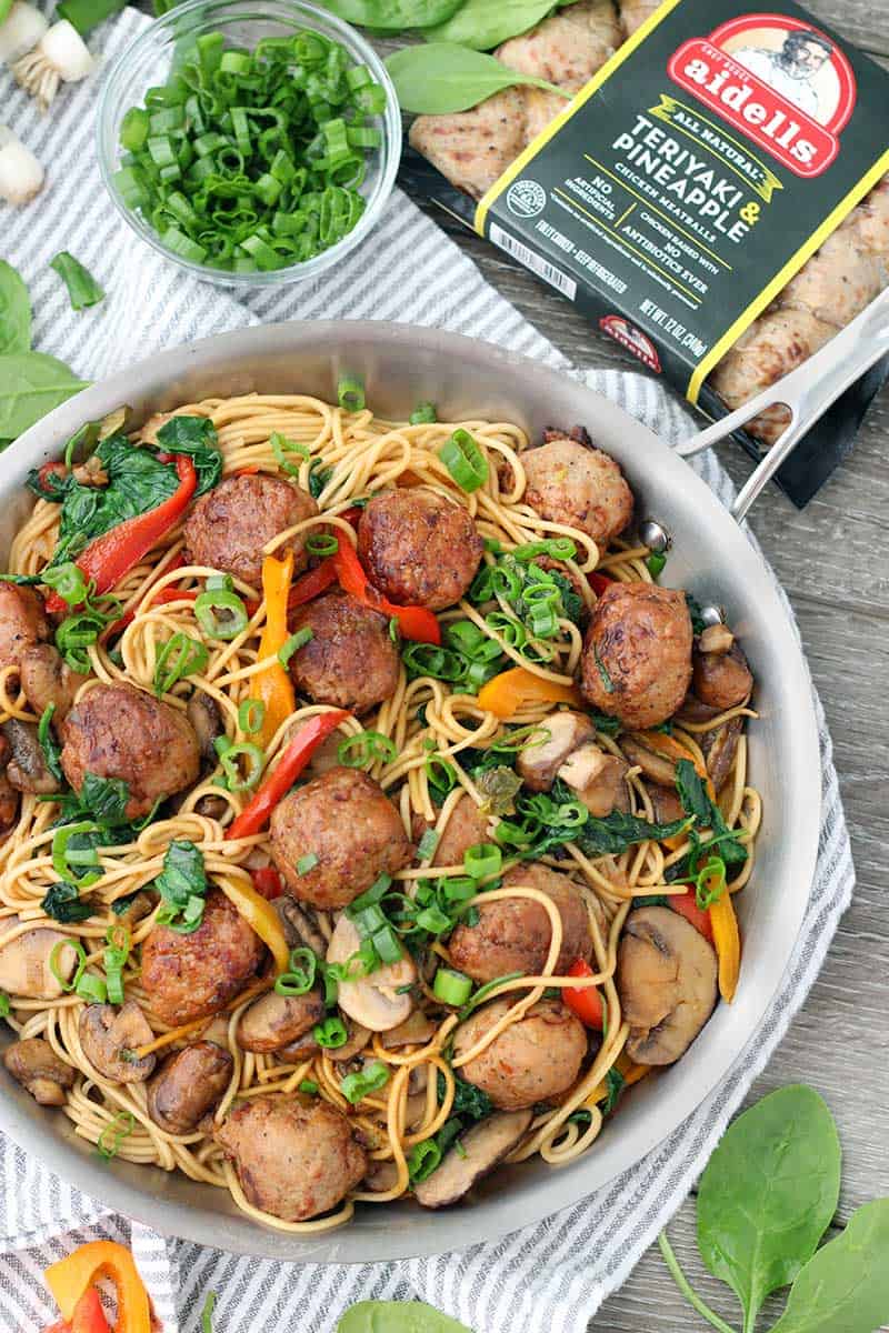 Overhead photo of a skillet of meatball lo mein with a package of Aidell's meatballs next to it.