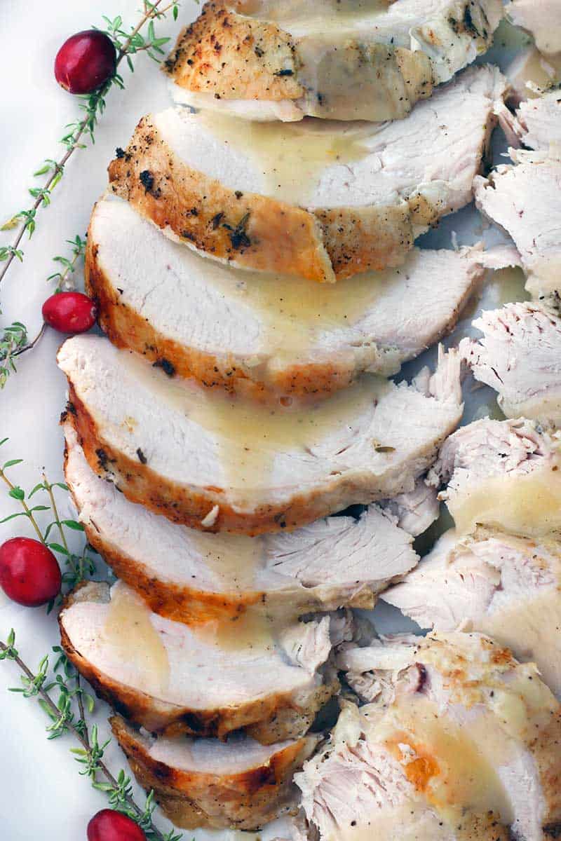 Close up photo of sliced turkey breast and gravy.