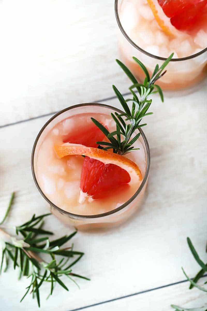 These Rosemary Greyhound Cocktails are made in batch, so they're easy to mix in advance for a party. This recipe uses grapefruit juice, vodka, and rosemary simple syrup- you can use seltzer for a virgin alternative.
