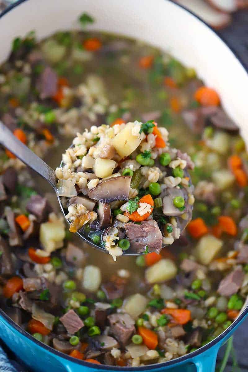 A ladle of beef barley soup.