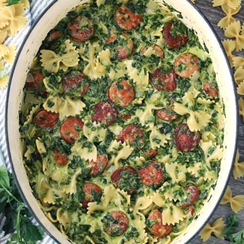 A Dutch Oven with sausage spinach pasta inside.
